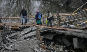 La gente cruza el río Irbin cerca de un puente destruido mientras son evacuados de la ciudad de Irbin, en medio de la invasión rusa de Ucrania, en las afueras de Kiev, Ucrania, el 1 de abril de 2022.