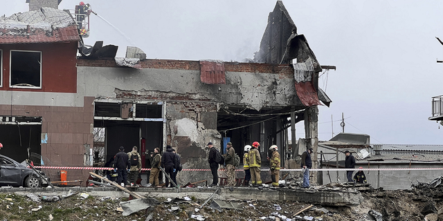 Los trabajadores de emergencia limpian los escombros después de un ataque aéreo contra una tienda de neumáticos en la ciudad occidental de Lviv, Ucrania, el lunes.