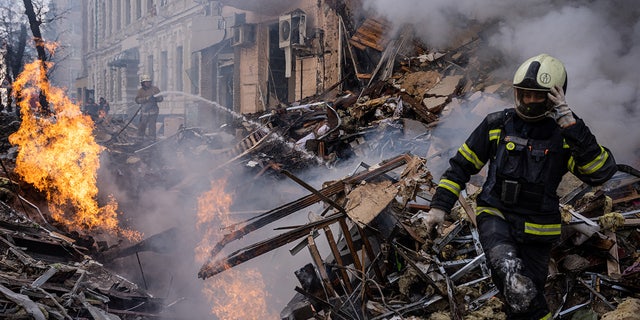 Los respondedores se ven en la escena después de que un edificio fue destruido en un ataque con misiles rusos en el centro de la ciudad de Kharkiv.