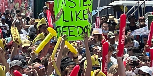 Una persona con un cartel que dice "Sabe a libertad" Durante el famoso concurso de perritos calientes de Nathan en Coney Island el 4 de julio de 2022.