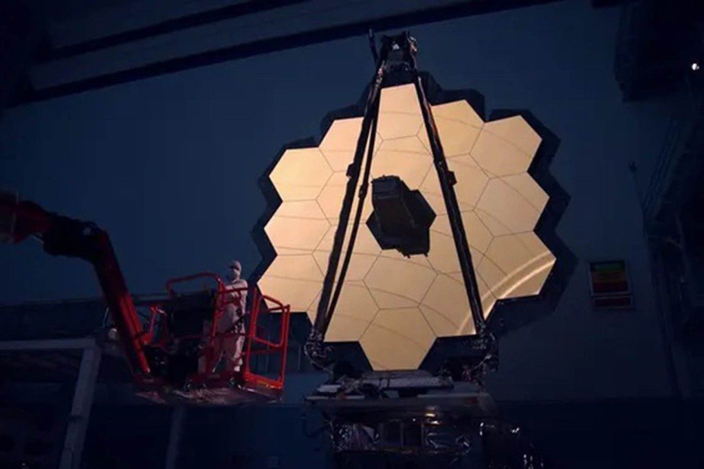 El espejo principal del Telescopio Espacial James Webb está iluminado en el cuarto oscuro