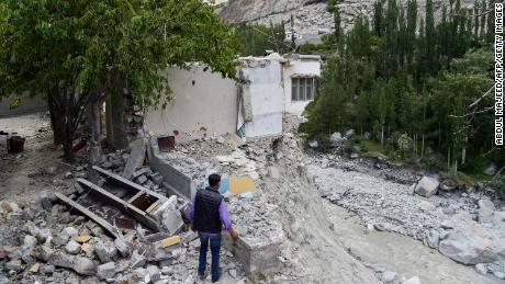Un residente local se encuentra junto a su casa destruida en junio después de que la explosión de un lago glacial causó inundaciones catastróficas en el pueblo de Hassanabad en el norte de Pakistán. 