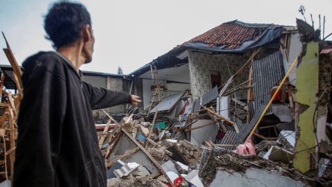 Un hombre se para cerca de las casas dañadas después del terremoto que azotó a Cianjur, provincia de Java Occidental, Indonesia, el 21 de noviembre de 2022.
