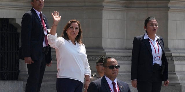 En medio de la seguridad, la presidenta peruana Dina Bolorati saluda a la prensa frente al Palacio de Gobierno mientras el primer ministro Alberto Otarola sale de Lima, Perú, el martes 10 de enero de 2023. 