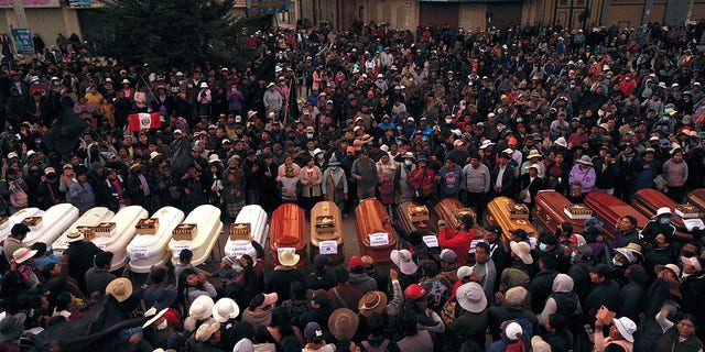 Los residentes rodean los ataúdes durante una vigilia por más de una docena de personas que murieron durante los disturbios en Juliaca, Perú, el martes 10 de enero de 2023.
