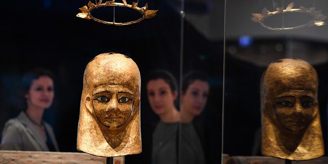 El personal del museo ve la máscara de momia de Moonstuff y la corona de Moonstuff en los Museos Nacionales de Escocia en Edimburgo.