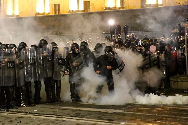 La policía antidisturbios bloquea una calle para detener a los manifestantes frente al edificio del Parlamento de Georgia en Tiflis.