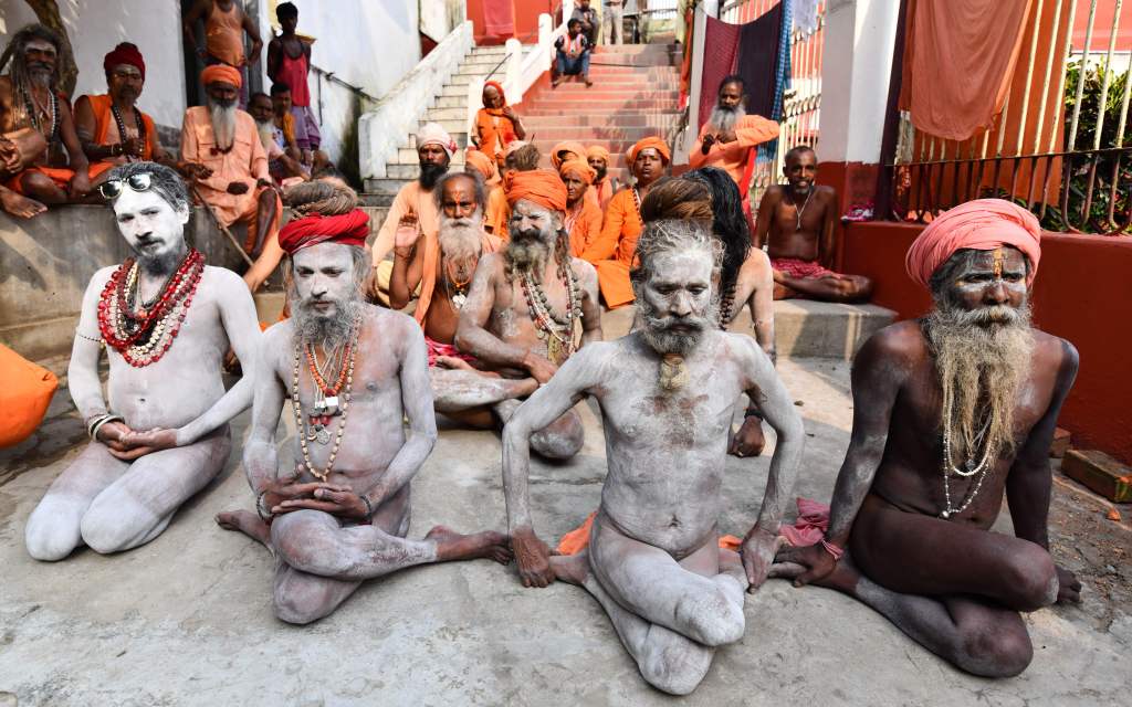 Monje indio - hombres santos hindúes - realizando yoga para celebrar el Día Internacional del Yoga en el Templo Kamakhya.