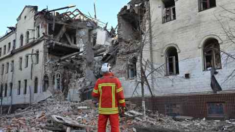 Un rescatista ucraniano junto a un edificio de apartamentos parcialmente destruido por un ataque con misiles en Járkov.